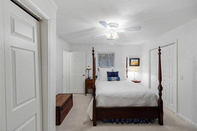 carpeted bedroom with ceiling fan and a closet