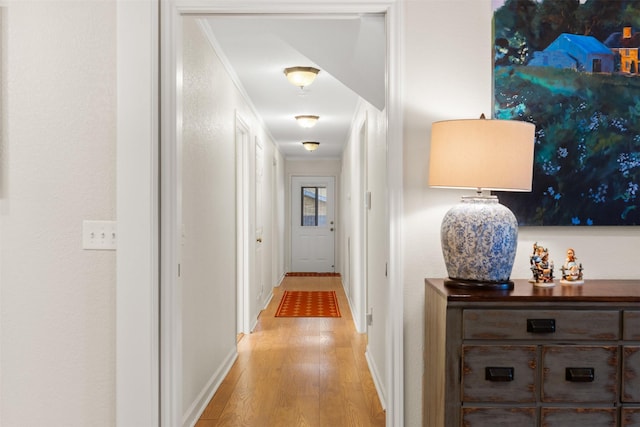 corridor with crown molding and light wood-type flooring