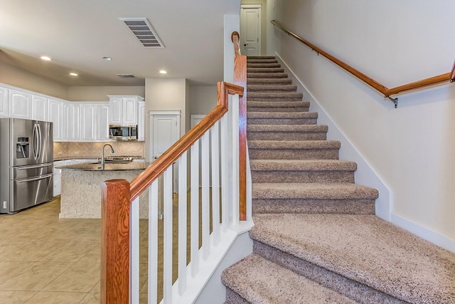 staircase with sink and tile patterned flooring