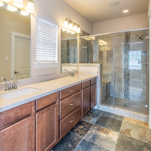 bathroom featuring a shower with shower door and vanity