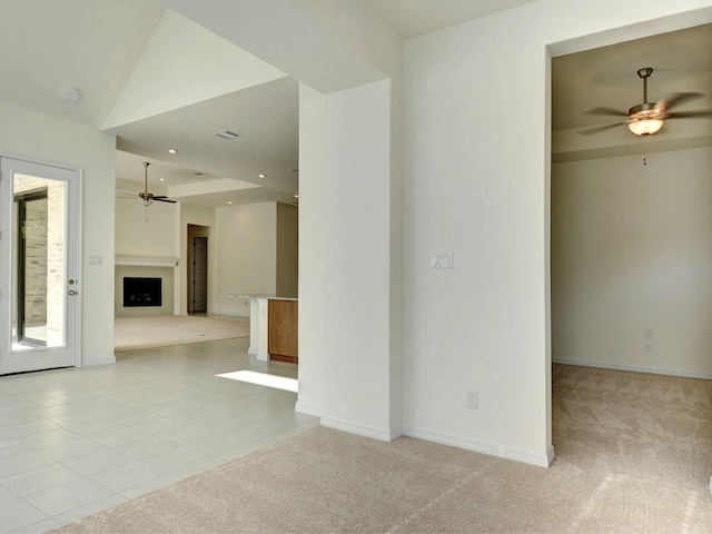 empty room featuring ceiling fan, vaulted ceiling, and light tile patterned floors