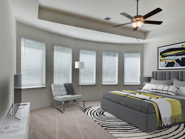 carpeted bedroom with ceiling fan, a raised ceiling, and multiple windows