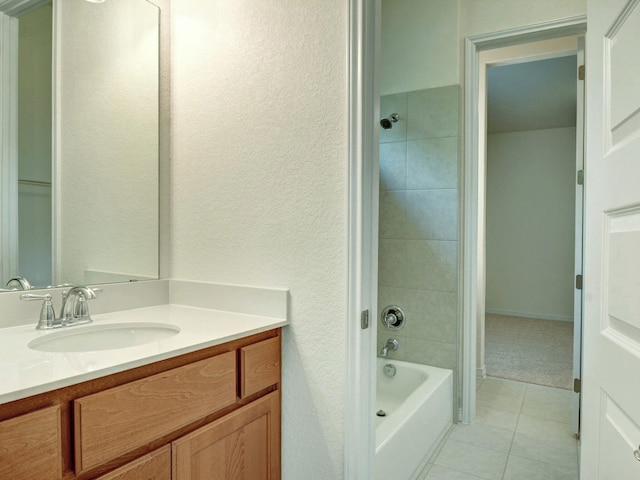 bathroom featuring vanity, tiled shower / bath, and tile patterned flooring