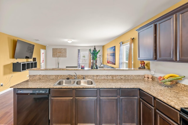 kitchen featuring dishwasher, dark wood-type flooring, sink, kitchen peninsula, and dark brown cabinets