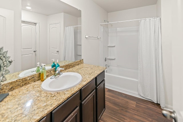 bathroom with hardwood / wood-style floors, vanity, and shower / bathtub combination with curtain