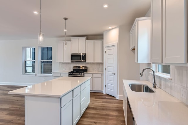 kitchen featuring sink, white cabinetry, stainless steel appliances, and a kitchen island