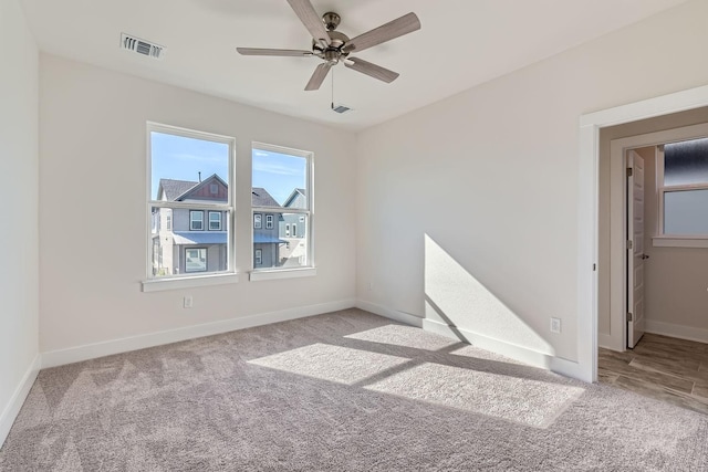 spare room with ceiling fan and light carpet