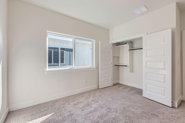 unfurnished bedroom with light carpet and a closet