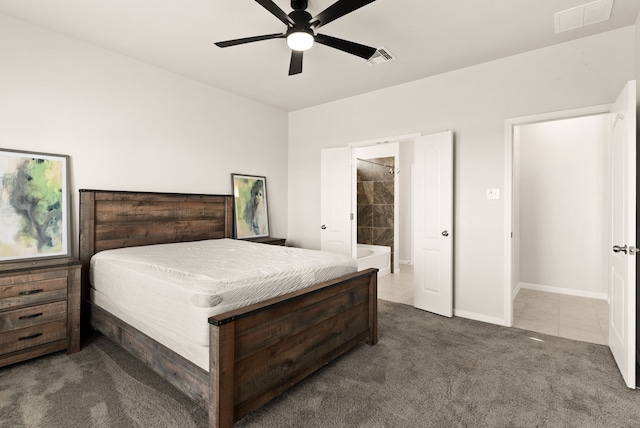 bedroom with ceiling fan, connected bathroom, and dark colored carpet