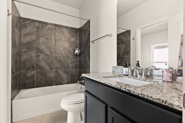 full bathroom featuring toilet, vanity, tiled shower / bath, and tile patterned flooring