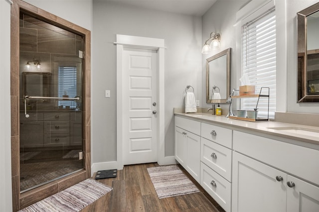 bathroom with a shower with shower door, wood-type flooring, and vanity