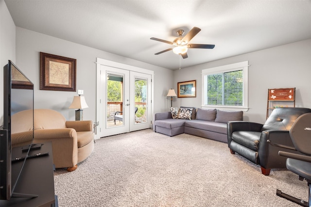 carpeted living room with ceiling fan and french doors