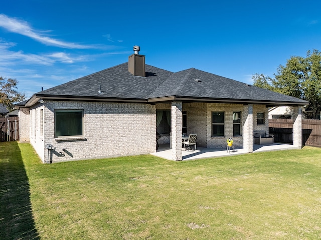 rear view of property featuring a patio area and a lawn