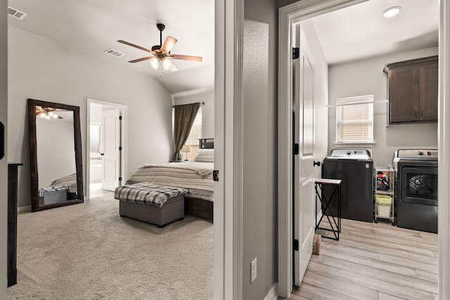 bedroom with ceiling fan, multiple windows, washer and clothes dryer, and light carpet