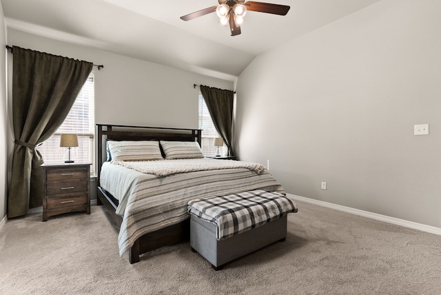 carpeted bedroom with ceiling fan, multiple windows, and vaulted ceiling