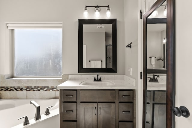 bathroom featuring a tub to relax in and vanity