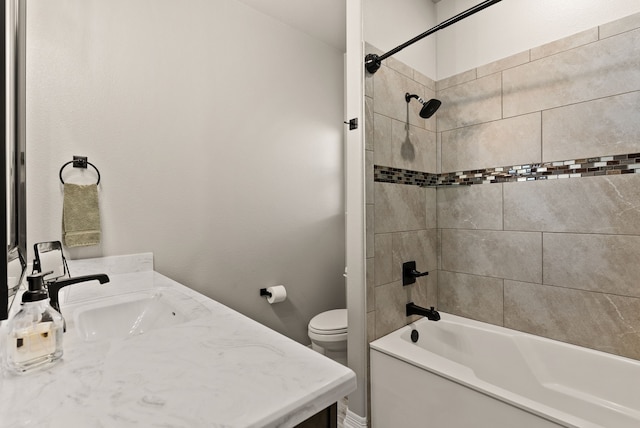 full bathroom with tiled shower / bath combo, toilet, and vanity