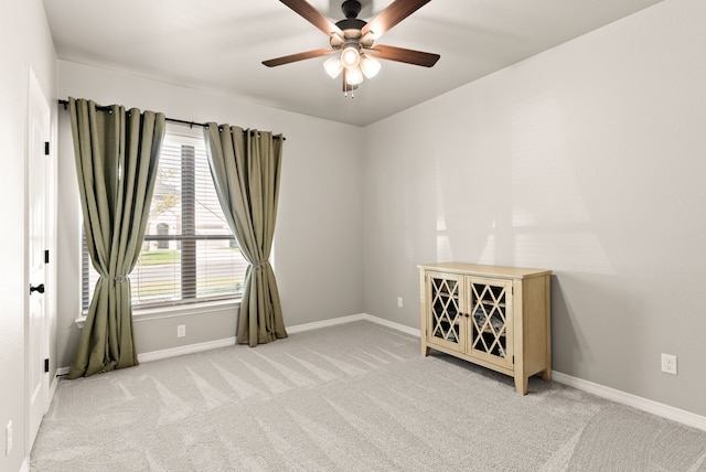 empty room featuring ceiling fan and light carpet