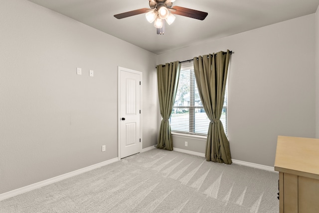 empty room featuring ceiling fan and light colored carpet