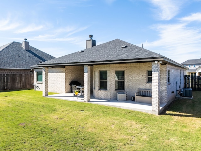 rear view of property featuring cooling unit, a patio, and a yard