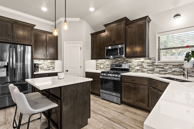 kitchen featuring appliances with stainless steel finishes, tasteful backsplash, hanging light fixtures, sink, and lofted ceiling