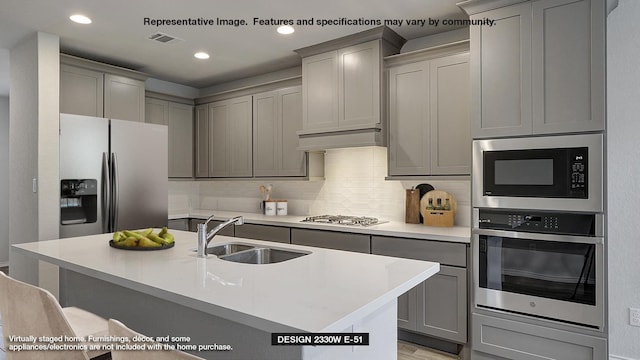 kitchen featuring sink, appliances with stainless steel finishes, gray cabinetry, and tasteful backsplash