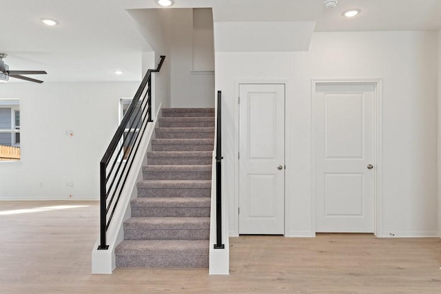 staircase featuring hardwood / wood-style flooring and ceiling fan