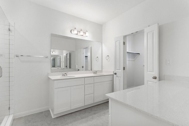 bathroom featuring a shower with door and vanity