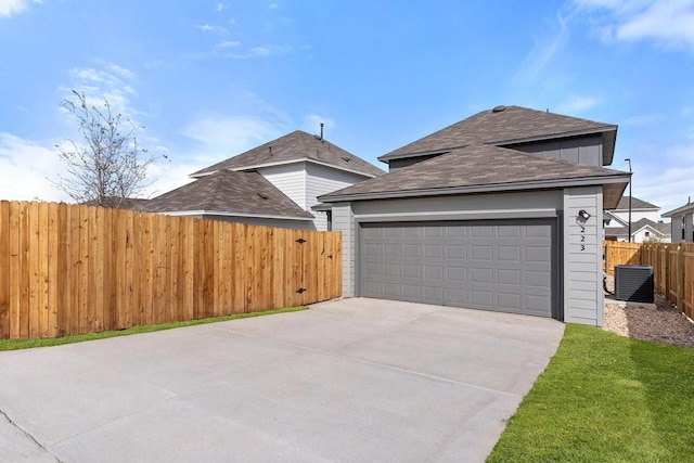 view of front of property featuring a garage and central AC