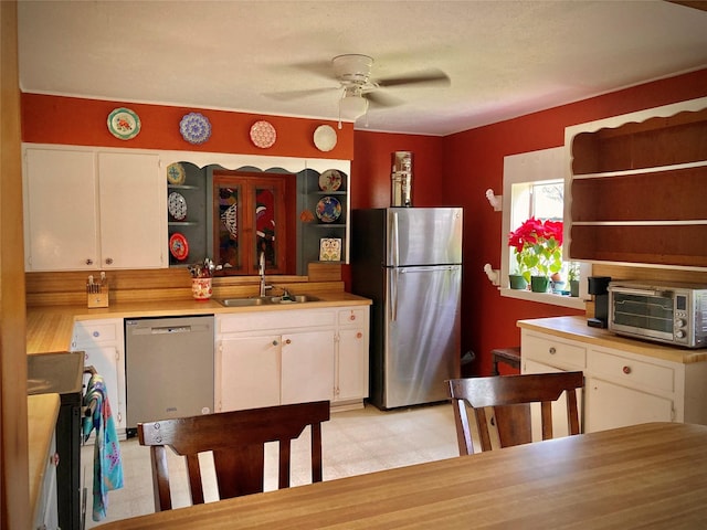 kitchen with ceiling fan, sink, white cabinets, and stainless steel appliances