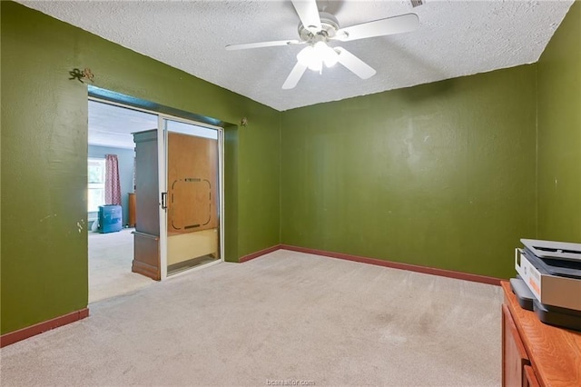 carpeted empty room with a textured ceiling and ceiling fan