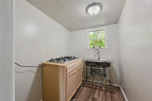 kitchen featuring sink, light brown cabinets, dark hardwood / wood-style floors, and stainless steel gas stovetop