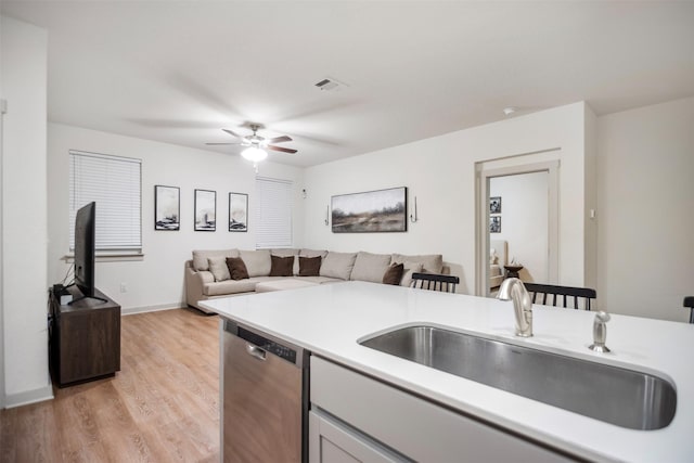 kitchen featuring sink, dishwasher, ceiling fan, and light hardwood / wood-style floors