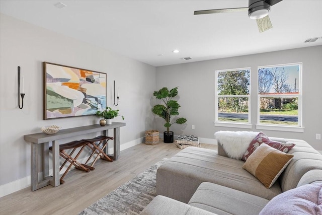 living room with ceiling fan and light hardwood / wood-style flooring