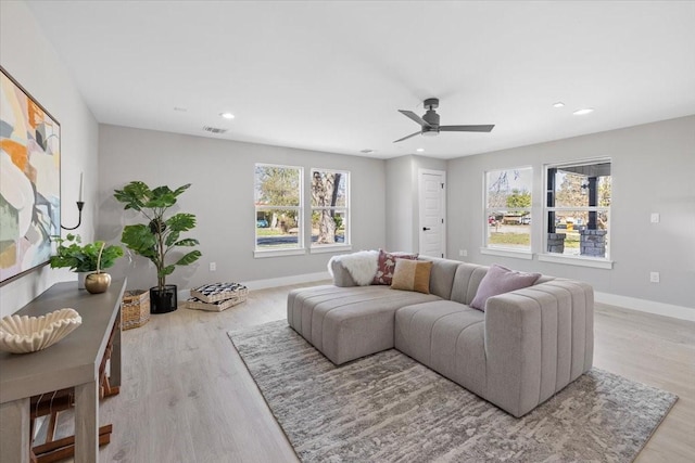 living room featuring light hardwood / wood-style floors and ceiling fan