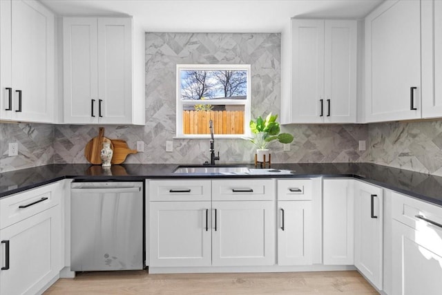 kitchen featuring sink, backsplash, white cabinetry, and dishwasher