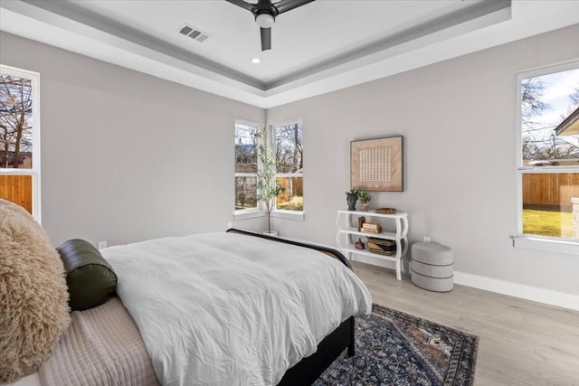 6003 Libyan Dr, Austin, TX 78745 - bedroom featuring a raised ceiling, baseboards, wood finished floors, multiple windows, and recessed lighting