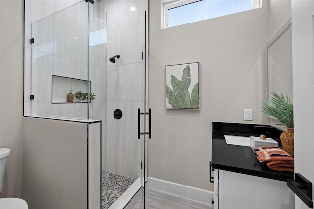 bathroom featuring a shower with shower door, wood-type flooring, toilet, and vanity