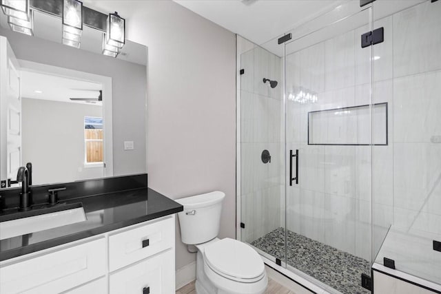 bathroom featuring vanity, toilet, and an enclosed shower