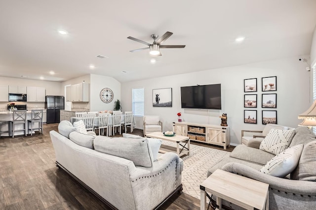 living room featuring ceiling fan and dark hardwood / wood-style flooring