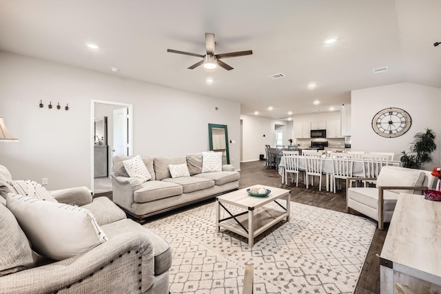 living room with vaulted ceiling, dark wood-type flooring, and ceiling fan