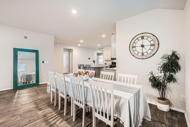 dining area featuring dark hardwood / wood-style floors and vaulted ceiling