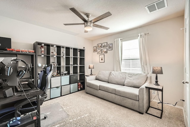 office space featuring ceiling fan, carpet floors, and a textured ceiling