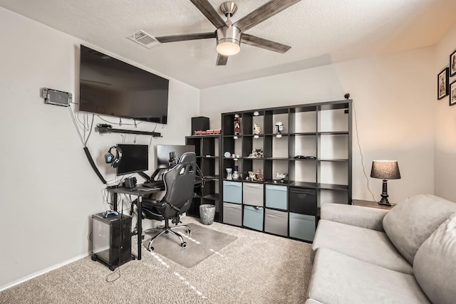 carpeted home office with ceiling fan and a textured ceiling