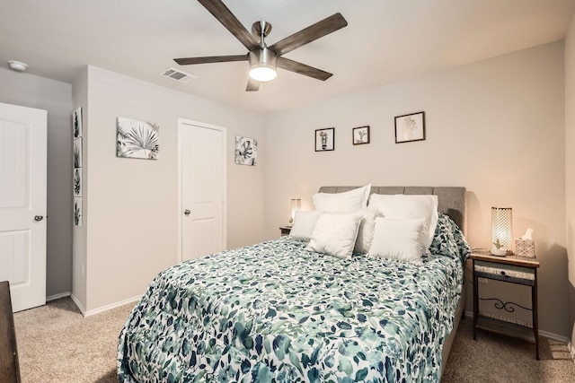 bedroom with light colored carpet, ceiling fan, and a closet