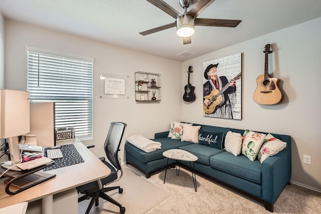 carpeted office space with ceiling fan