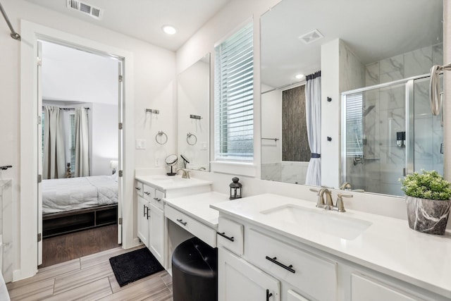 bathroom with a shower with door and vanity