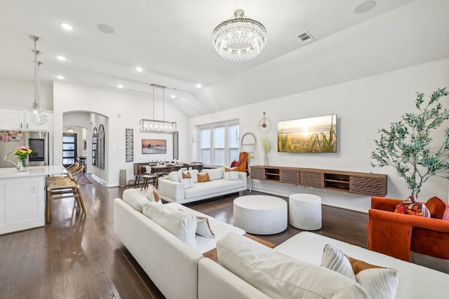 living room with dark hardwood / wood-style floors, lofted ceiling, and a chandelier