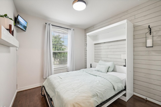 bedroom featuring wood walls and dark hardwood / wood-style floors