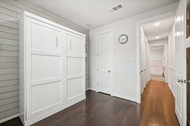 unfurnished bedroom with dark hardwood / wood-style floors and a closet